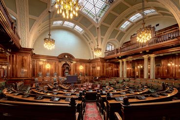 Large legislative chamber with chandeliers hanging from ceiling