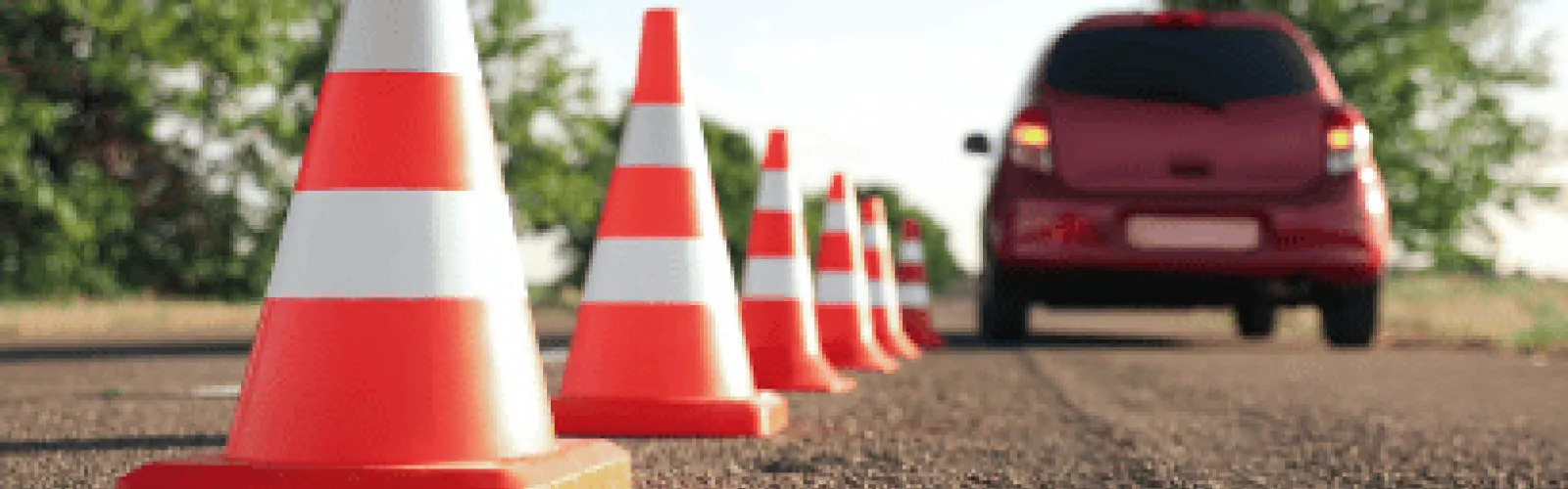 Car stopped next to traffic cones