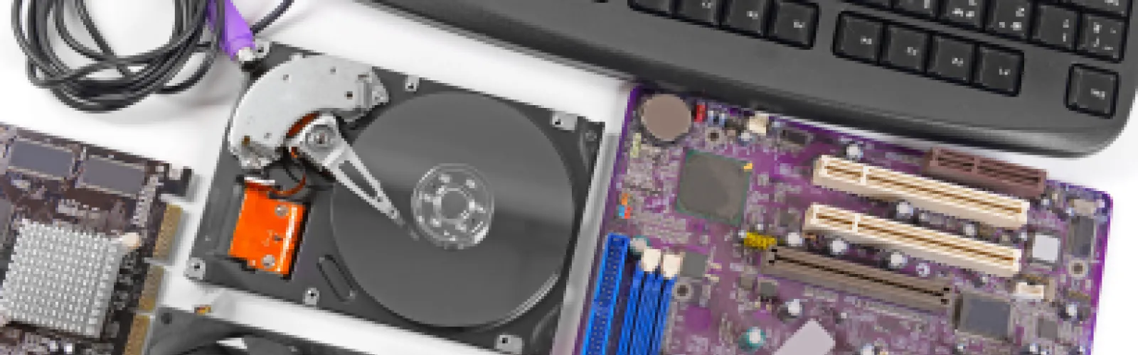 Computer parts next to a keyboard.