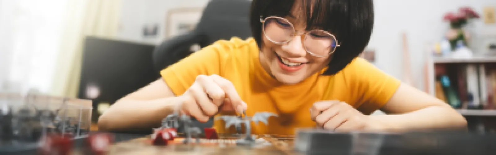 A young woman playing dungeons and dragons, moving a figurine on a table full of red dice.