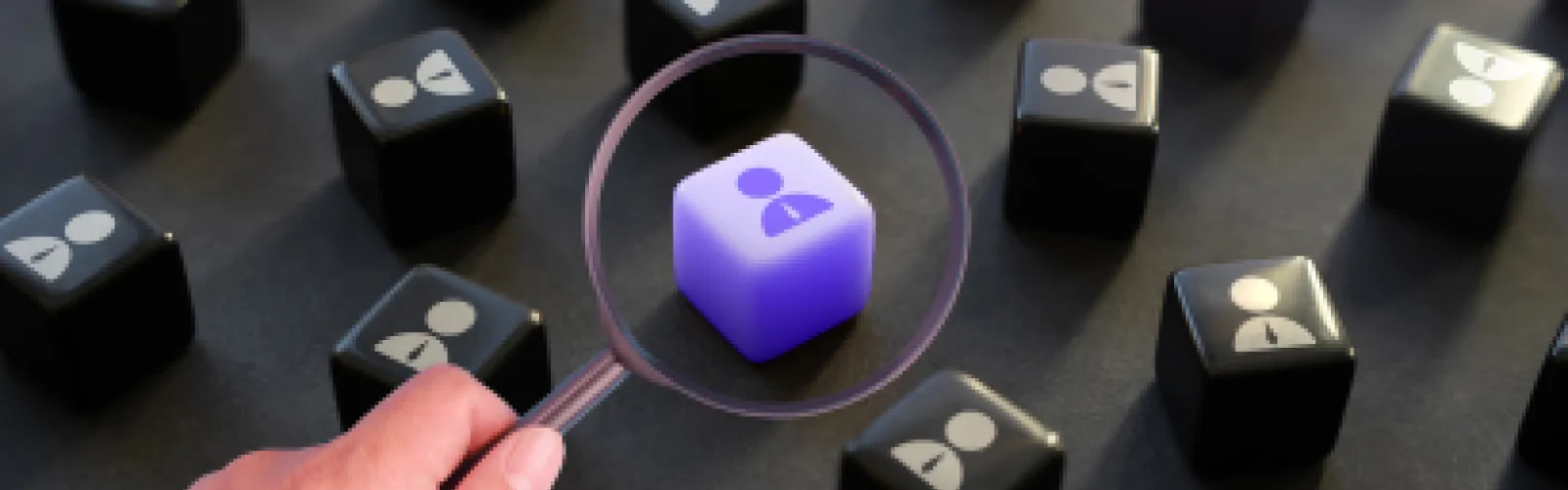 Dice with people silhouettes, one purple, the rest black, the purple on is magnified by a magnifying lens