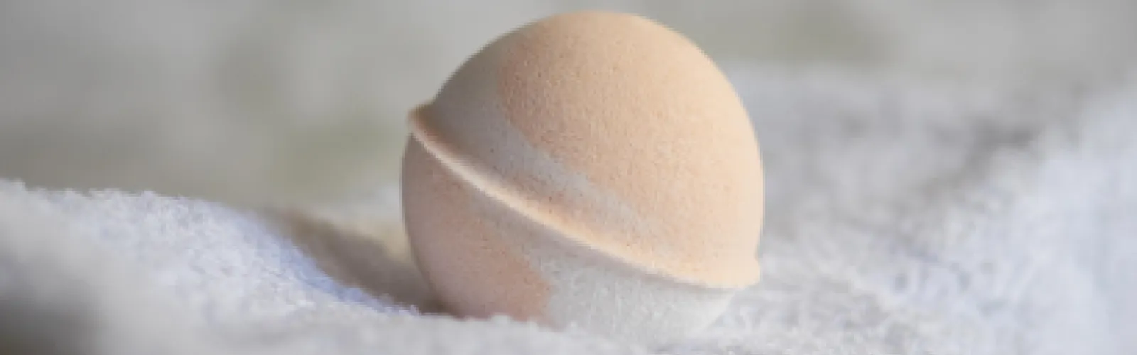 beige bath bomb on a white towel