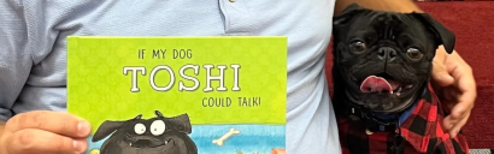 Toshi the therapy dog with a book.